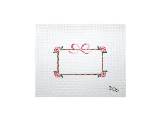 Embroidered design of a frame with flowers and a bow on a white background