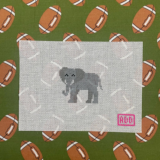Cross-stitch pattern of a bear on a white fabric square with footballs patterned on a green background