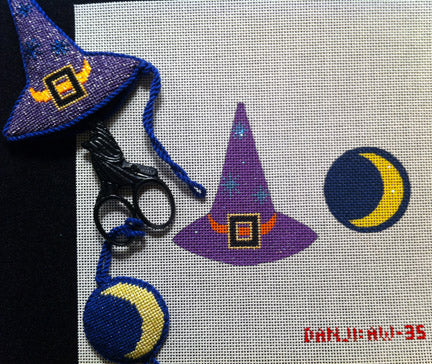 Witch hat and moon design with scissors on a cross-stitched background