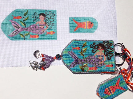 Cross-stitched mermaid design on fabric with keychain and zipper pull