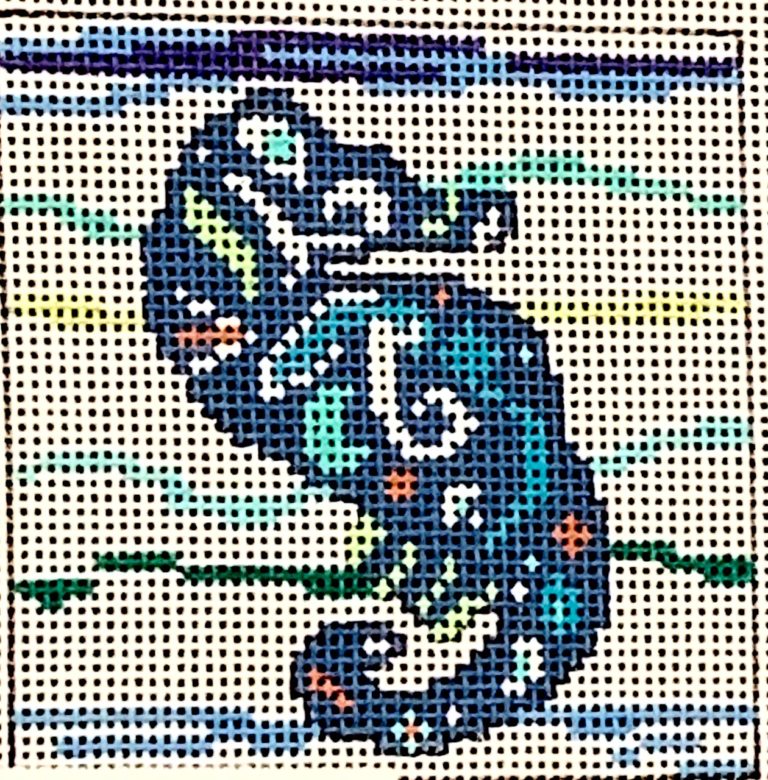 Cross-stitched design of a blue dragon on a white fabric background