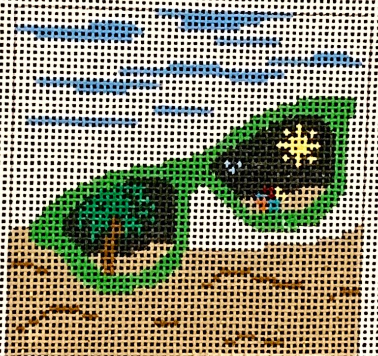Cross-stitched green glasses with star on a beige fabric background