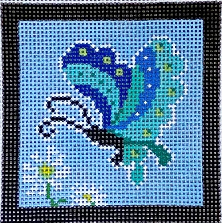 Cross-stitched design of a blue cat on a light blue background