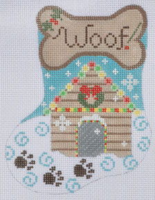 Cross-stitched design of a doghouse with 'Woof' bone above, on a blue background.