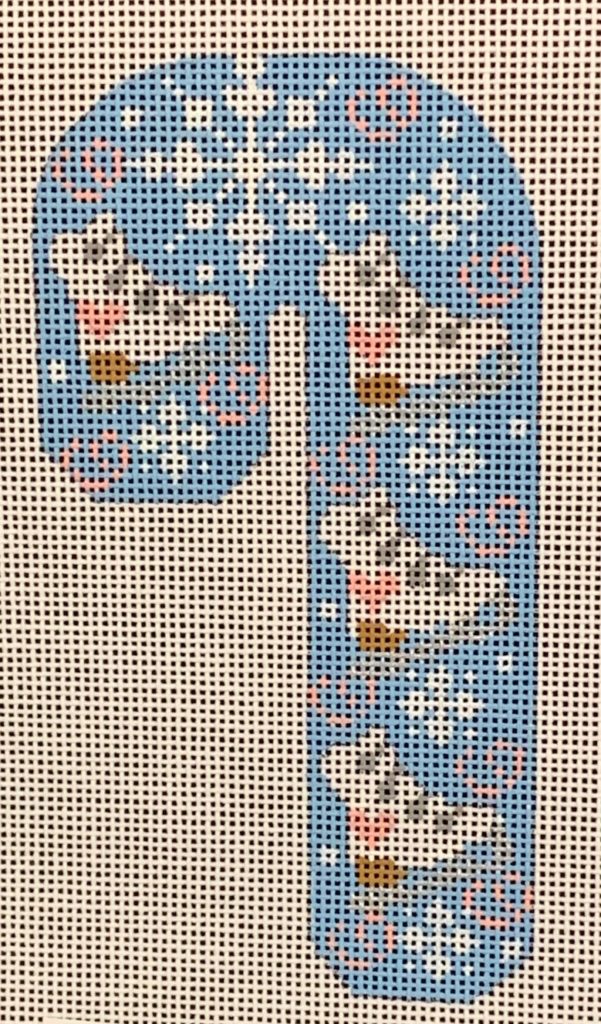 Cross-stitched candy cane design on fabric with a beige background