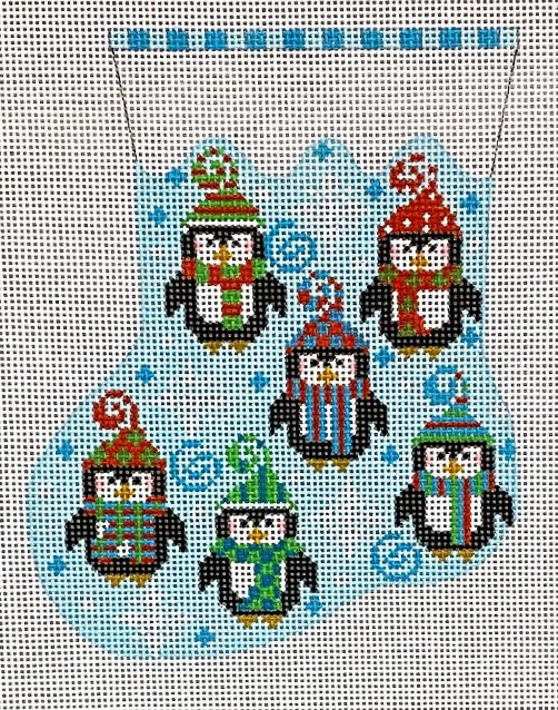 Cross-stitched pattern of penguins wearing colorful hats and scarves on a blue background.
