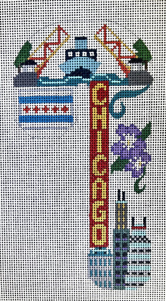 Decorative needlepoint of a Chicago-themed design with a sign, boat, and skyline.