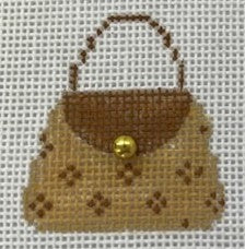 Cross-stitched miniature handbag with a brown handle and gold button on a white background