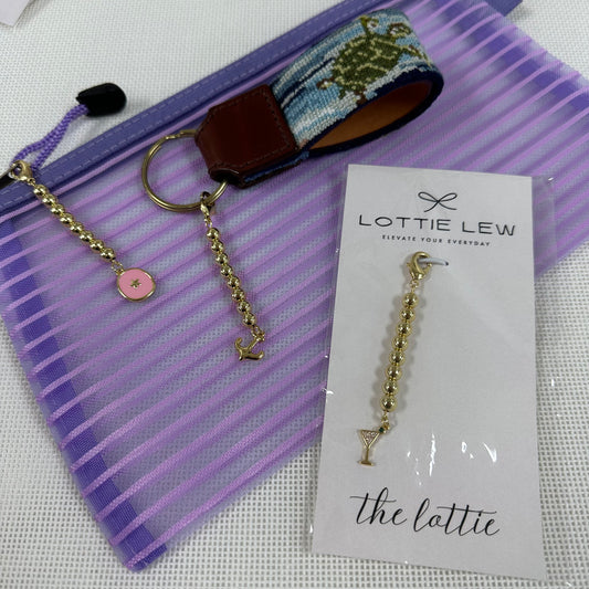 Gold keychain with charms, accompanied by a card featuring 'Lottie Lew' branding.