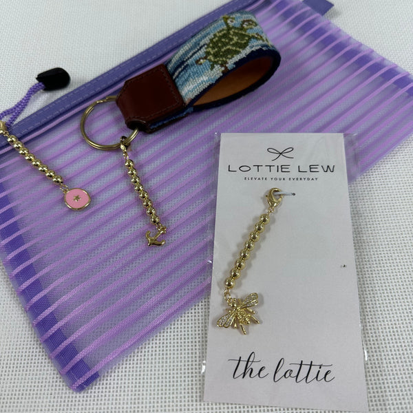 Gold keychain with bee charm on a Lottie Lew card against a purple striped background