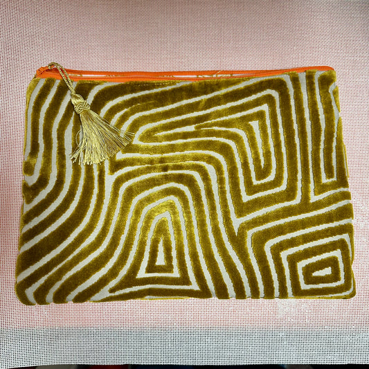 Velvet pouch with wavy pattern and tassel on a textured background