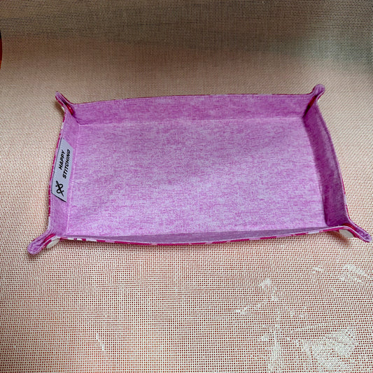 Purple fabric tray with a label on a beige surface