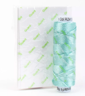 Turquoise yarn roll with a white label on a white background