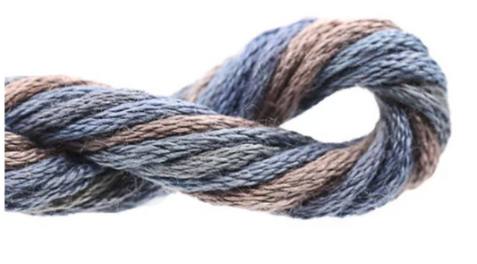 Coiled skein of yarn with blue and brown tones on a white background