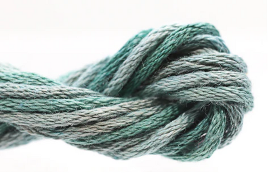 Close-up of a skein of teal yarn on a white background
