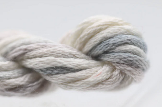 Ball of gray and white yarn on a light background