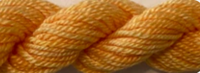 A close-up of a twisted yarn or thread skein in a warm mustard yellow color, filling the entire frame.