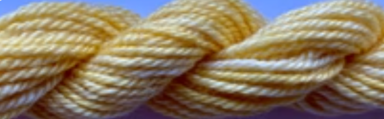 A close-up of a twisted skein of pale yellow yarn or thread against a light blue background.